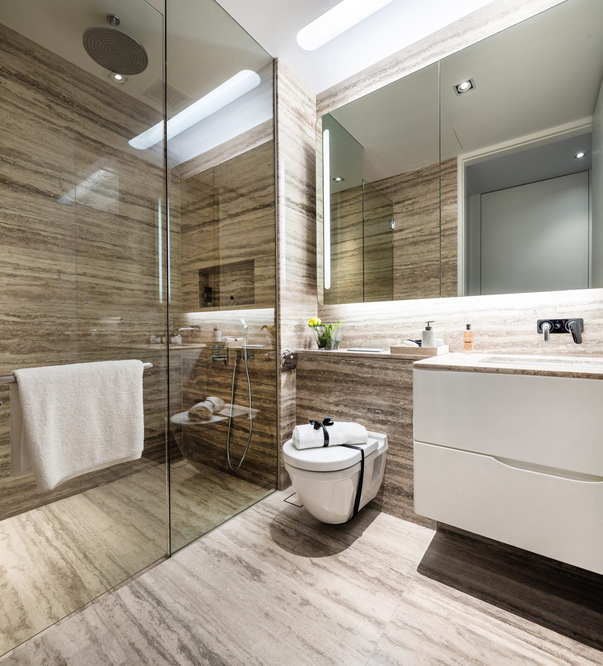 Bathroom suite with a rain shower and marble-clad walls